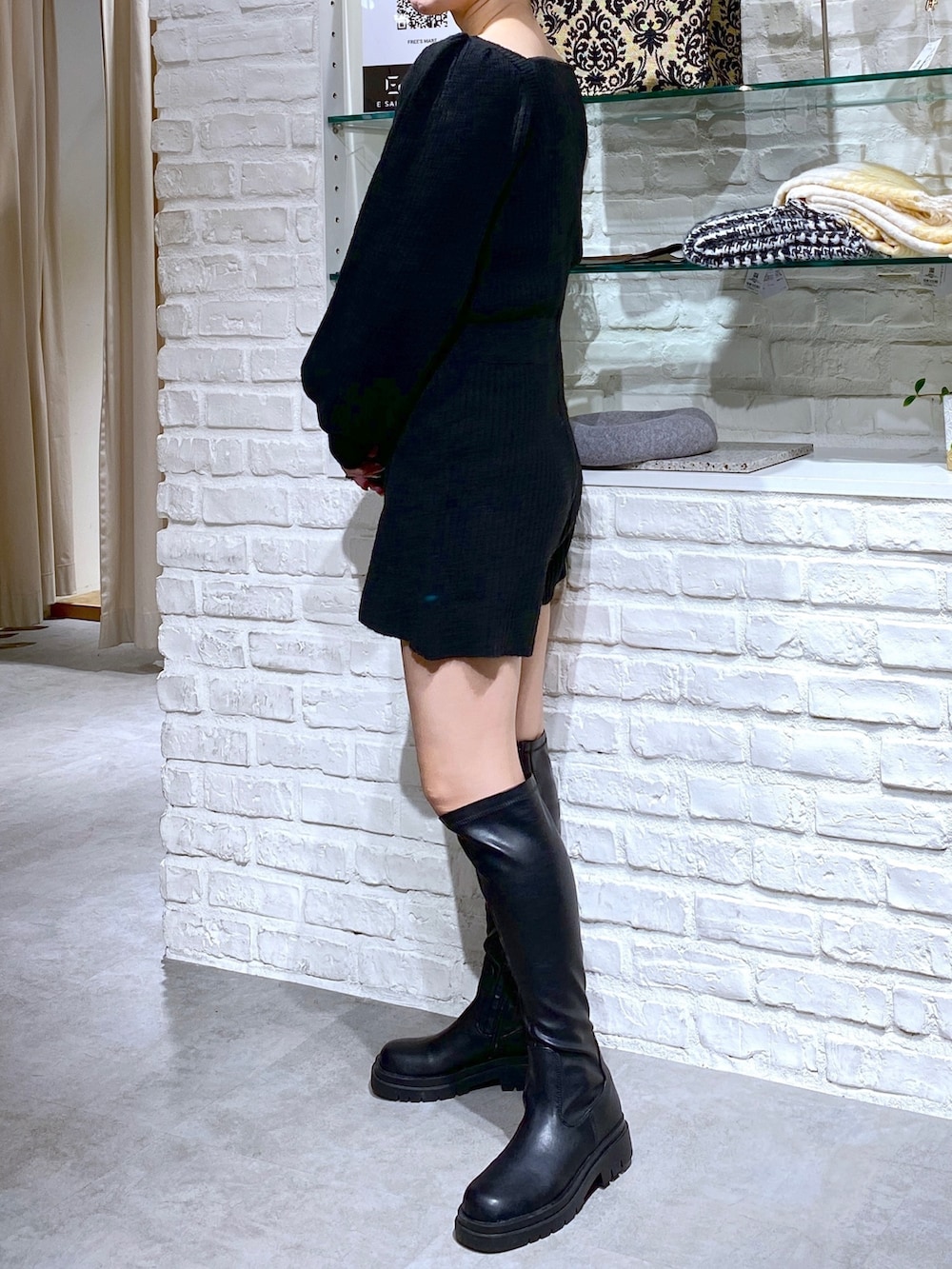ブラック系のブーツ、ブラック系のワンピースを着用したレディースの冬コーディネートの2枚目の写真