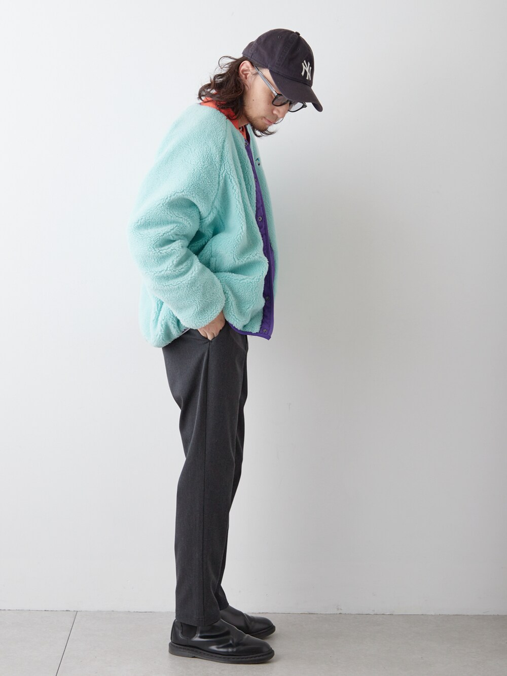 ブラック系のブーツ、グレー系のパンツ、オレンジ系のニット/セーターを着用したメンズの冬コーディネートの2枚目の写真