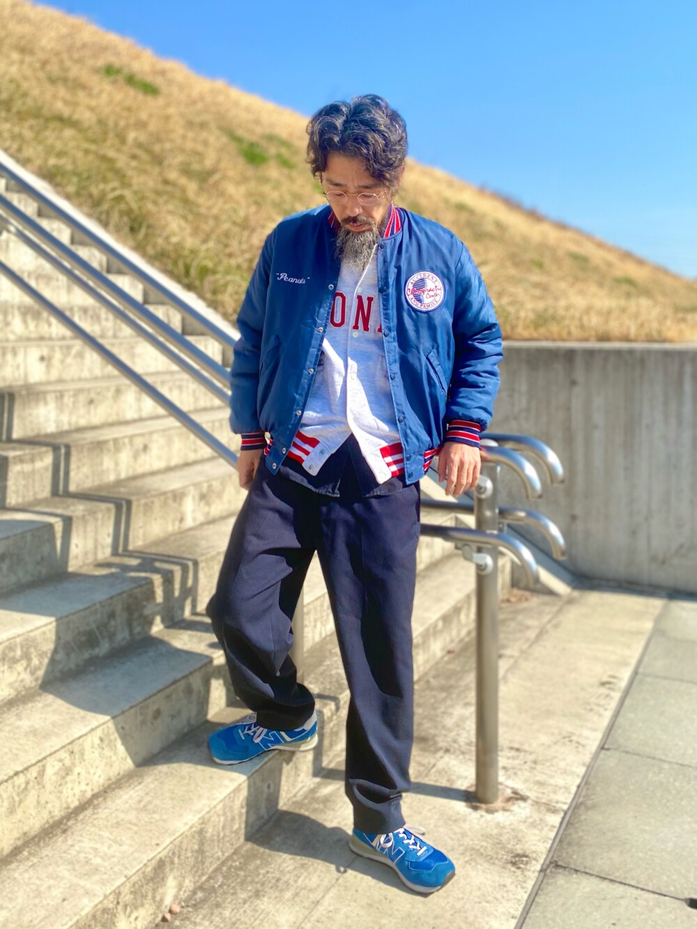 ブルー系のスラックス、ブルー系のスニーカー、ブルー系のスタジャンを着用したメンズの春コーディネートの2枚目の写真