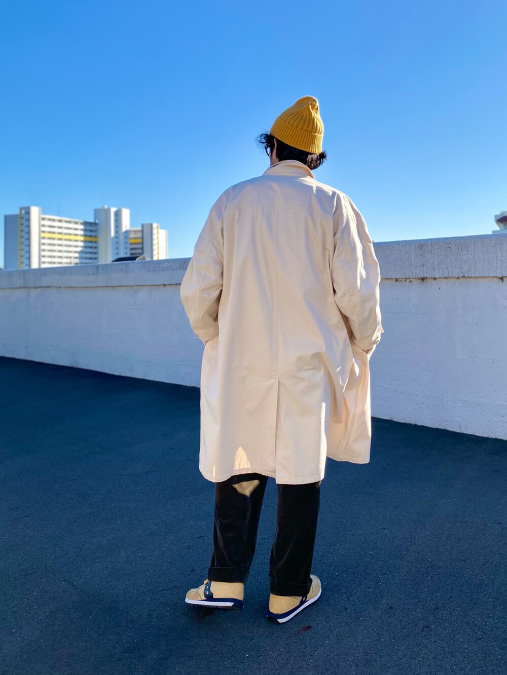 「コート、ロングコート、デニム、カバーオール、スニーカー、ニット帽、レイヤードスタイル、アメカジ、古着MIX、休日スタイル、冬コーデ、お出かけコーデ、冬アウター、ビッグシルエット、大人カジュアル」｜「UNIQLOのアイテム（ニットキャップ/ビーニー、イエロー系）」を使った、ヤギハシカズヒロさん（メンズ・181cm）の冬コーディネートの3枚目の写真