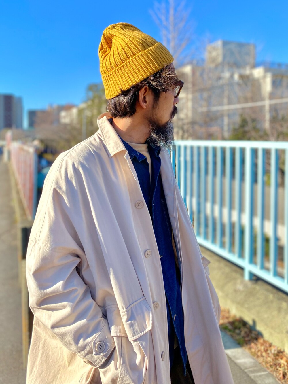 「コート、ロングコート、デニム、カバーオール、スニーカー、ニット帽、レイヤードスタイル、アメカジ、古着MIX、休日スタイル、冬コーデ、お出かけコーデ、冬アウター、ビッグシルエット、大人カジュアル」｜「UNIQLOのアイテム（ニットキャップ/ビーニー、イエロー系）」を使った、ヤギハシカズヒロさん（メンズ・181cm）の冬コーディネートの4枚目の写真