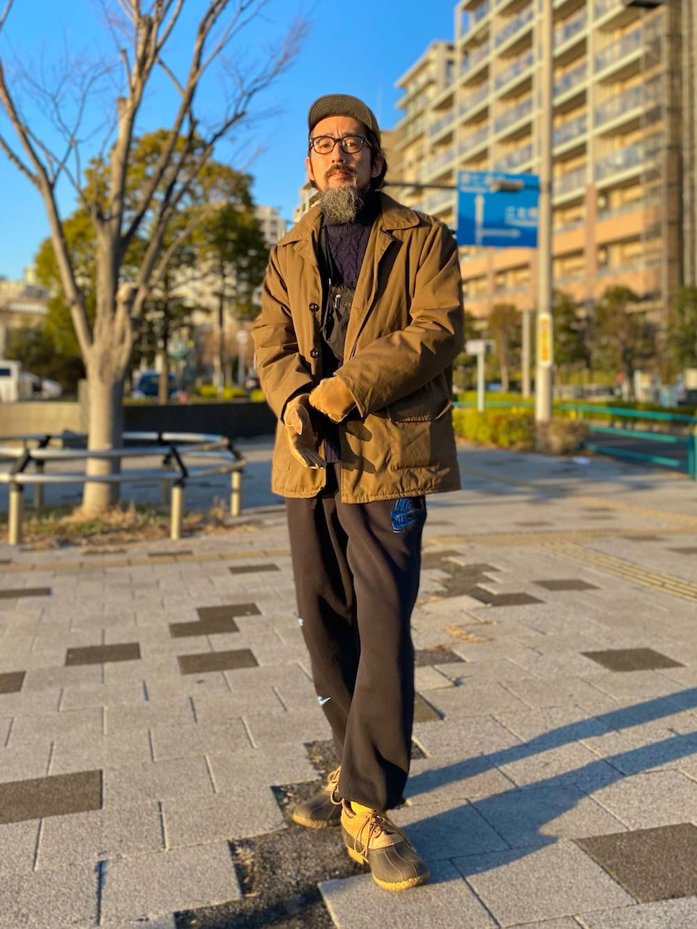 ブラウン系のその他アウター、ブルー系のニット/セーター、ブラック系のショルダーバッグを着用したメンズの冬コーディネートの2枚目の写真