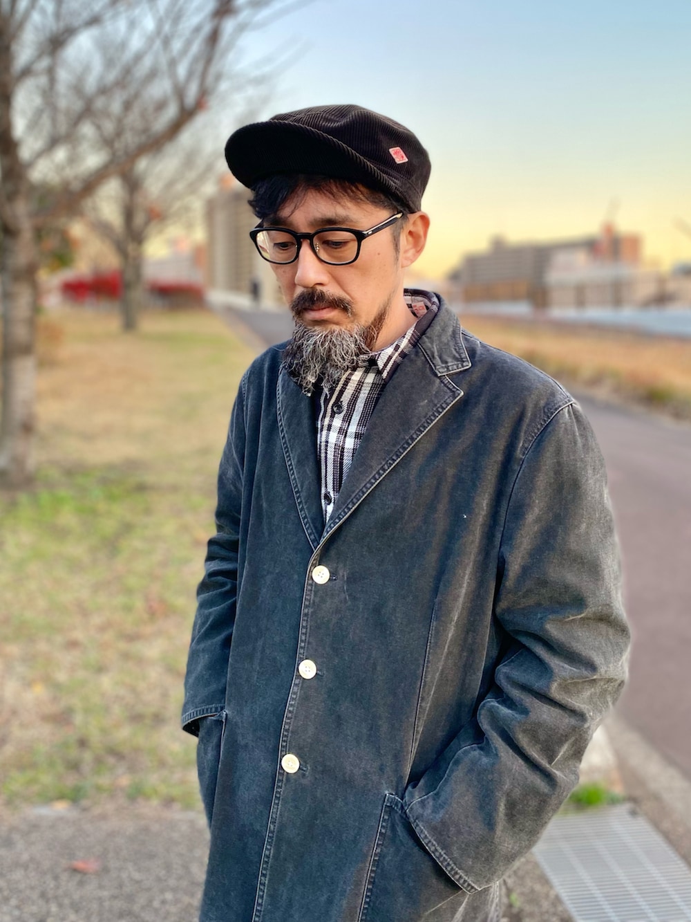 グレー系のデニムパンツ、ブラック系のスニーカー、ブラック系のテーラードジャケットを着用したメンズの冬コーディネートの2枚目の写真