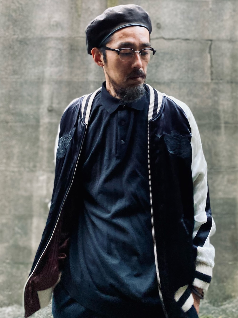 ブルー系のスラックス、ブラック系のその他シューズ、ブラック系のポロシャツを着用したメンズの冬コーディネートの2枚目の写真