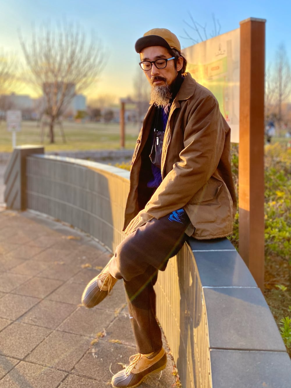 ブラウン系のその他アウター、ブルー系のニット/セーター、ブラック系のショルダーバッグを着用したメンズの冬コーディネートの3枚目の写真