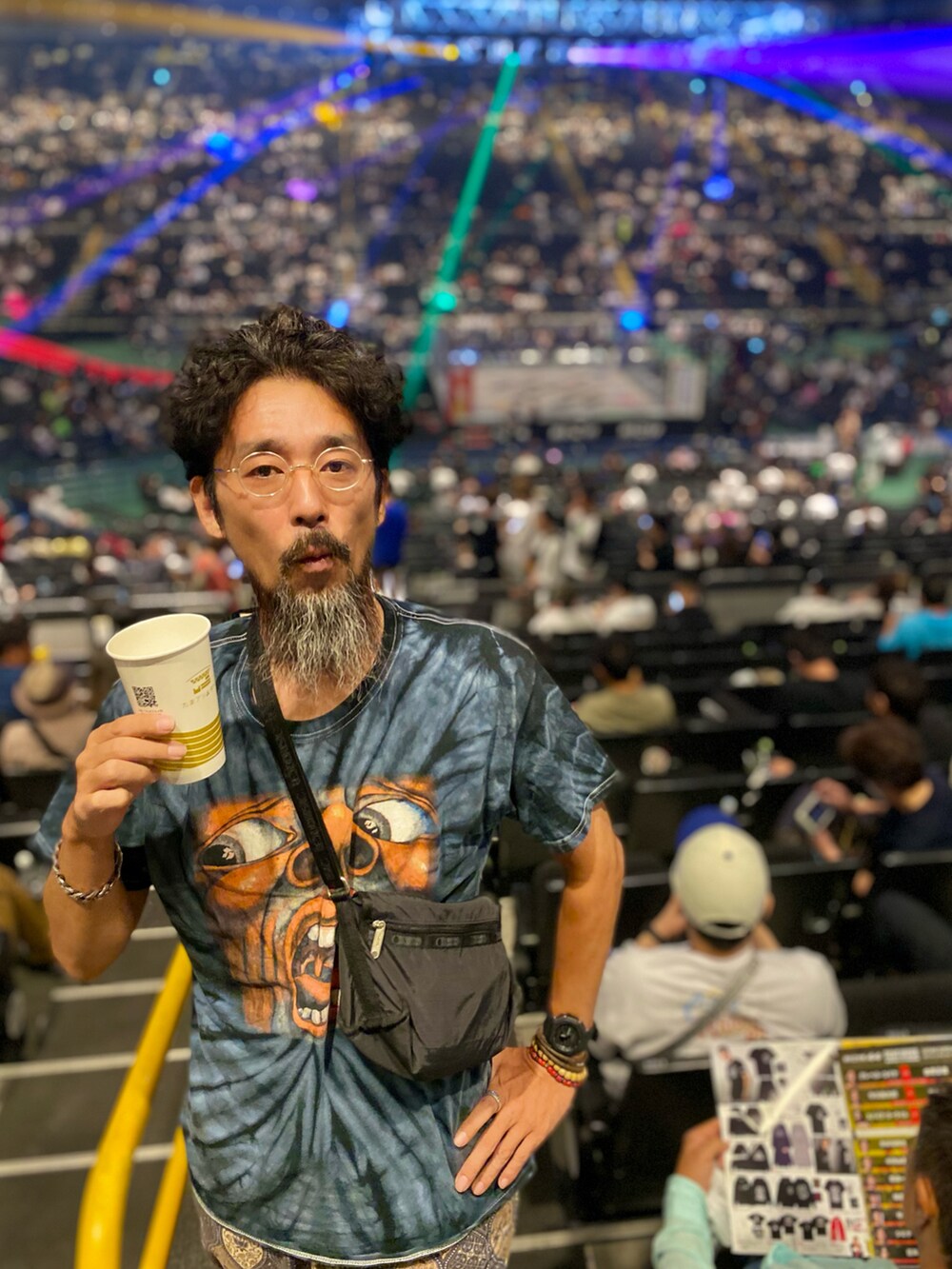 「休日スタイル、タイダイ柄、バンドT、イージーパンツ、柄パンツ、柄×柄、スリッポン、カラー×コーデ、ショルダーバッグ、メガネ男子、お出かけコーデ、秋服まるっと大公開、秋コーデ、リラックススタイル、メンズファッション」|「LeSportsacのアイテム(ショルダーバッグ、ブラック系)」を使った、ヤギハシカズヒロさん(メンズ・181cm)の秋コーディネートの2枚目の写真