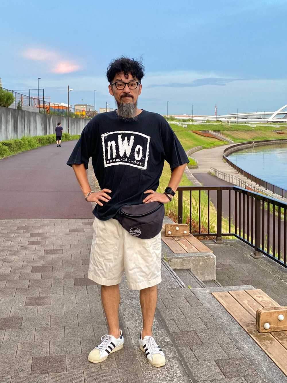 ブラック系のTシャツ/カットソー、グレー系のボディバッグ/ウエストポーチ、ホワイト系のその他パンツを着用したメンズの夏コーディネートの2枚目の写真