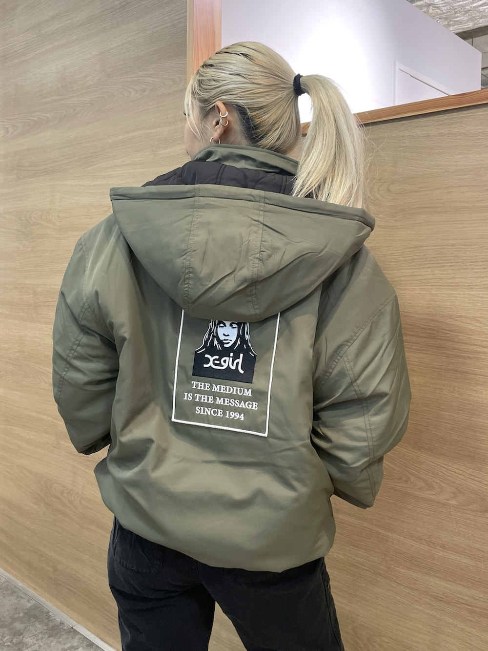 グリーン系のナイロンジャケット、ブラック系のその他パンツを着用したレディースの秋コーディネートの2枚目の写真