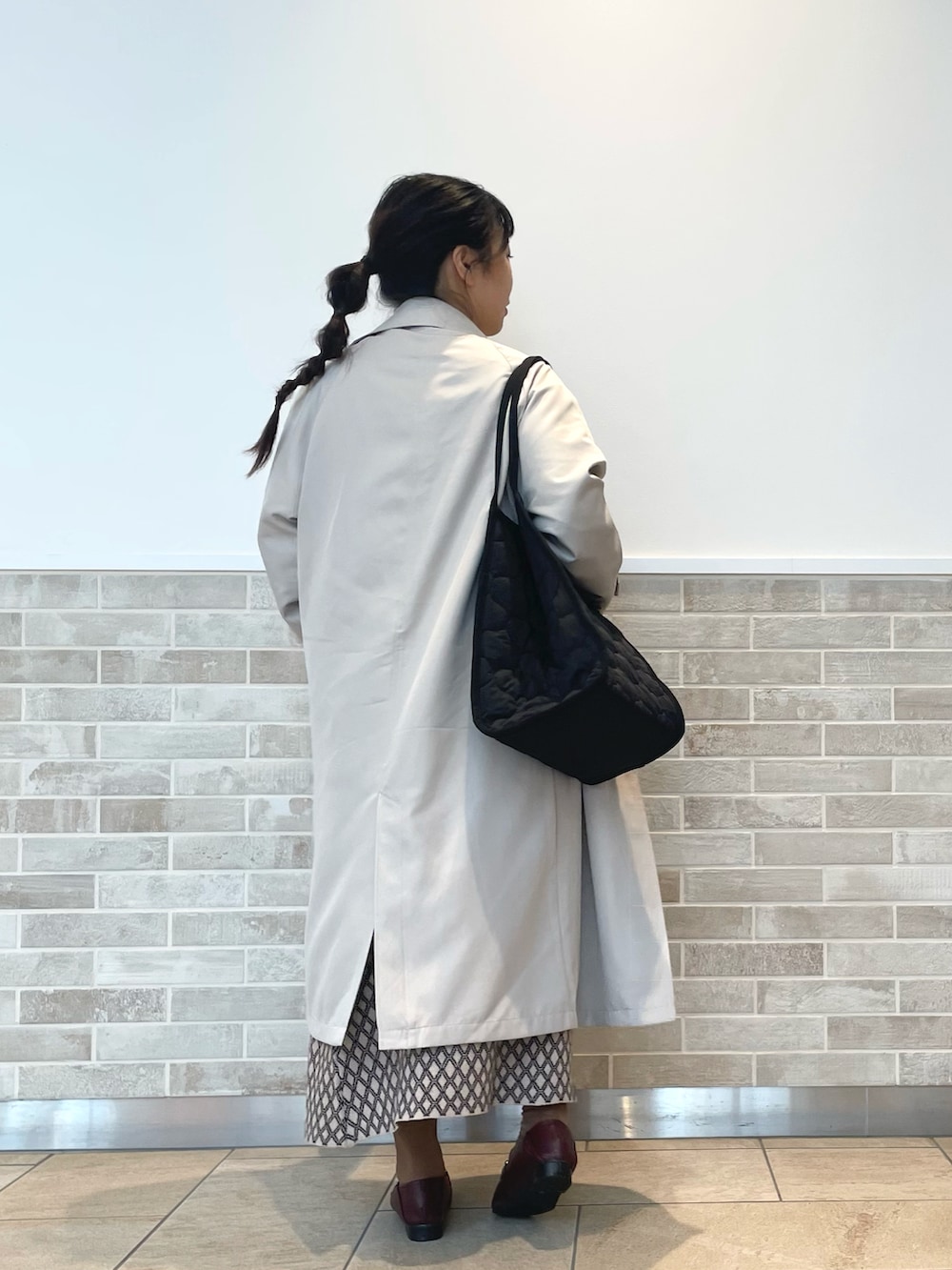 ブラウン系のニット/セーター、ブラウン系のスカート、ブラウン系のドレスシューズを着用したレディースの秋コーディネートの2枚目の写真