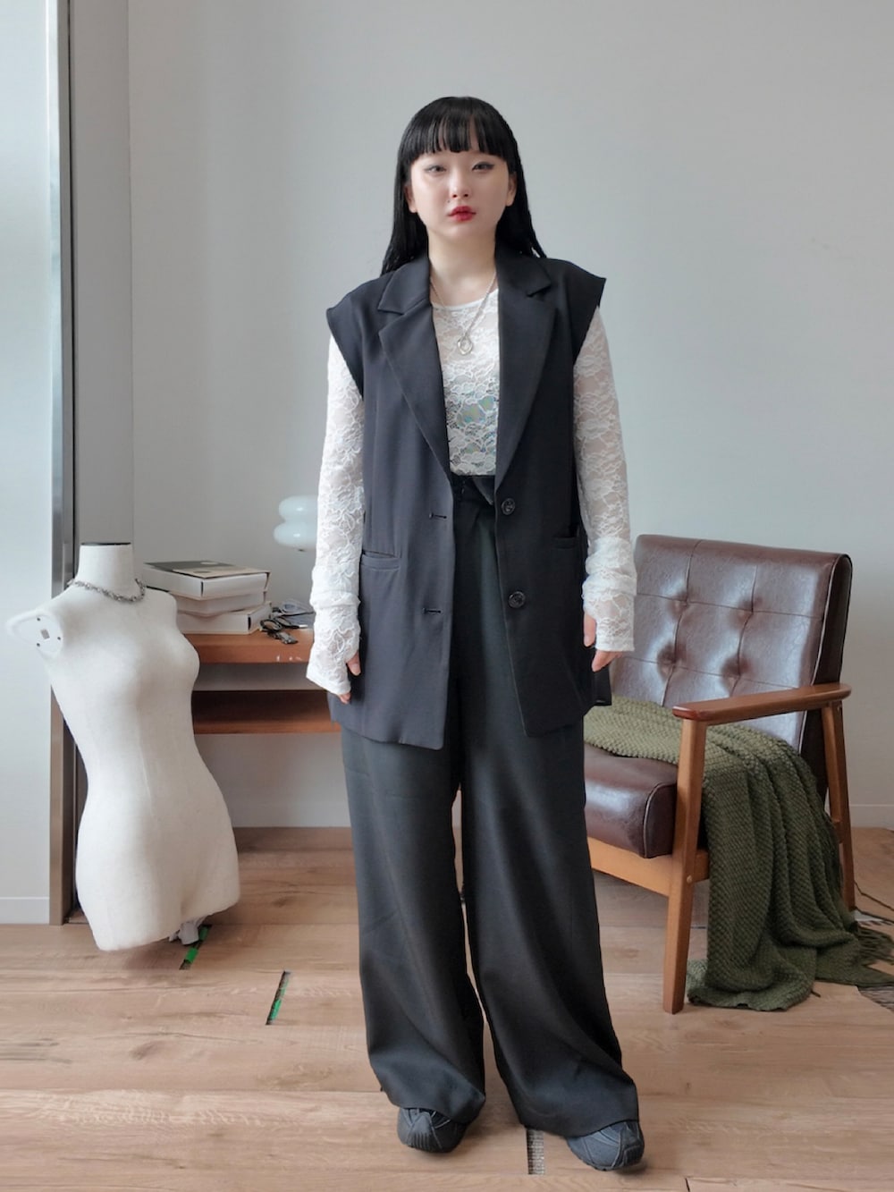 ホワイト系のTシャツ/カットソー、ブラック系のベスト、ブラック系のスラックスを着用したレディースの夏コーディネートの3枚目の写真