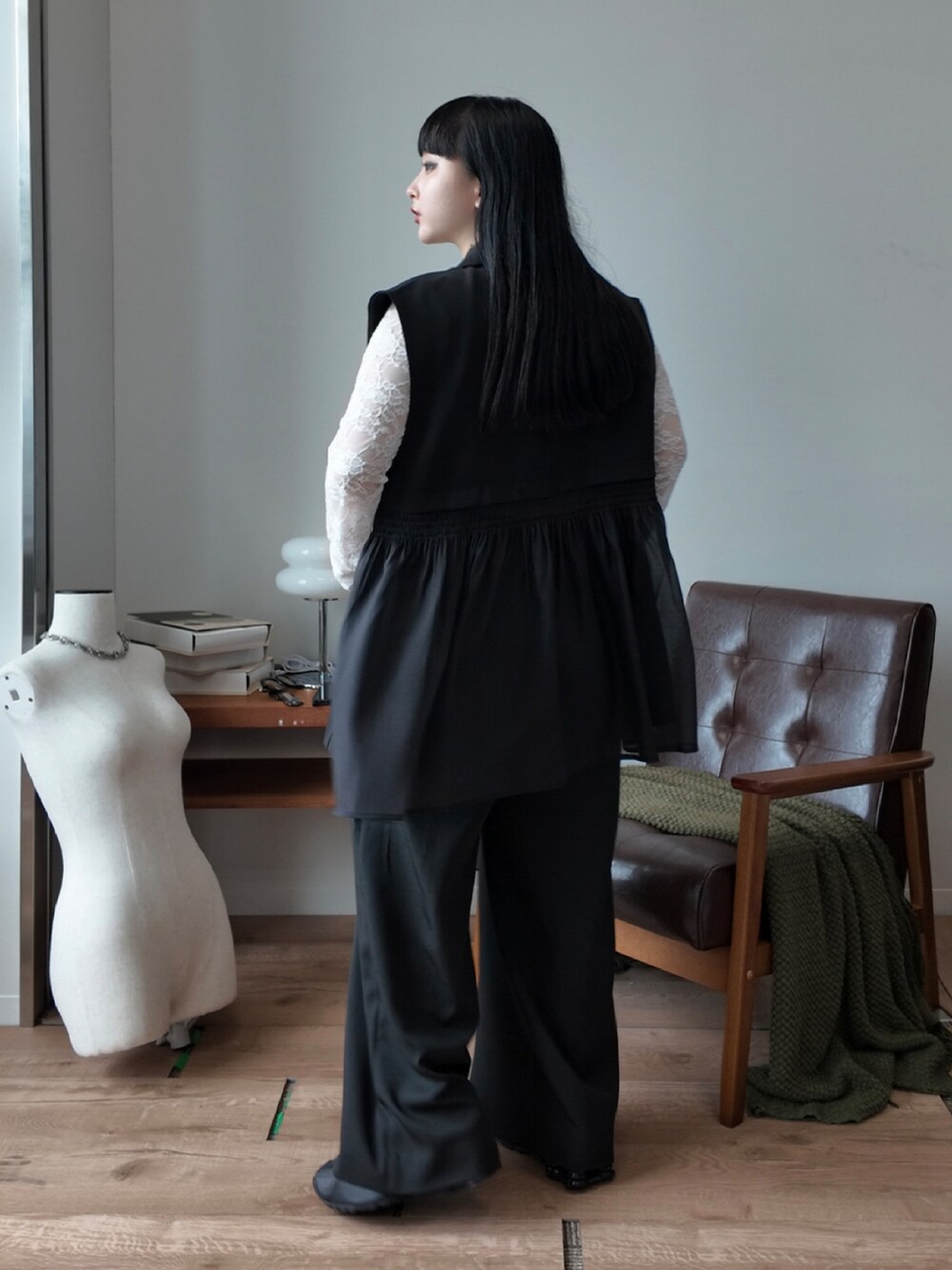 ホワイト系のTシャツ/カットソー、ブラック系のベスト、ブラック系のスラックスを着用したレディースの夏コーディネートの2枚目の写真