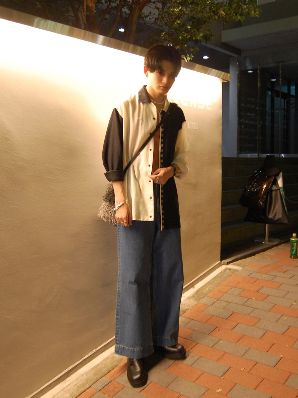 ブルー系のデニムパンツ、ブラック系のドレスシューズ、ブラック系のシャツ/ブラウスを着用したメンズの夏コーディネートの2枚目の写真