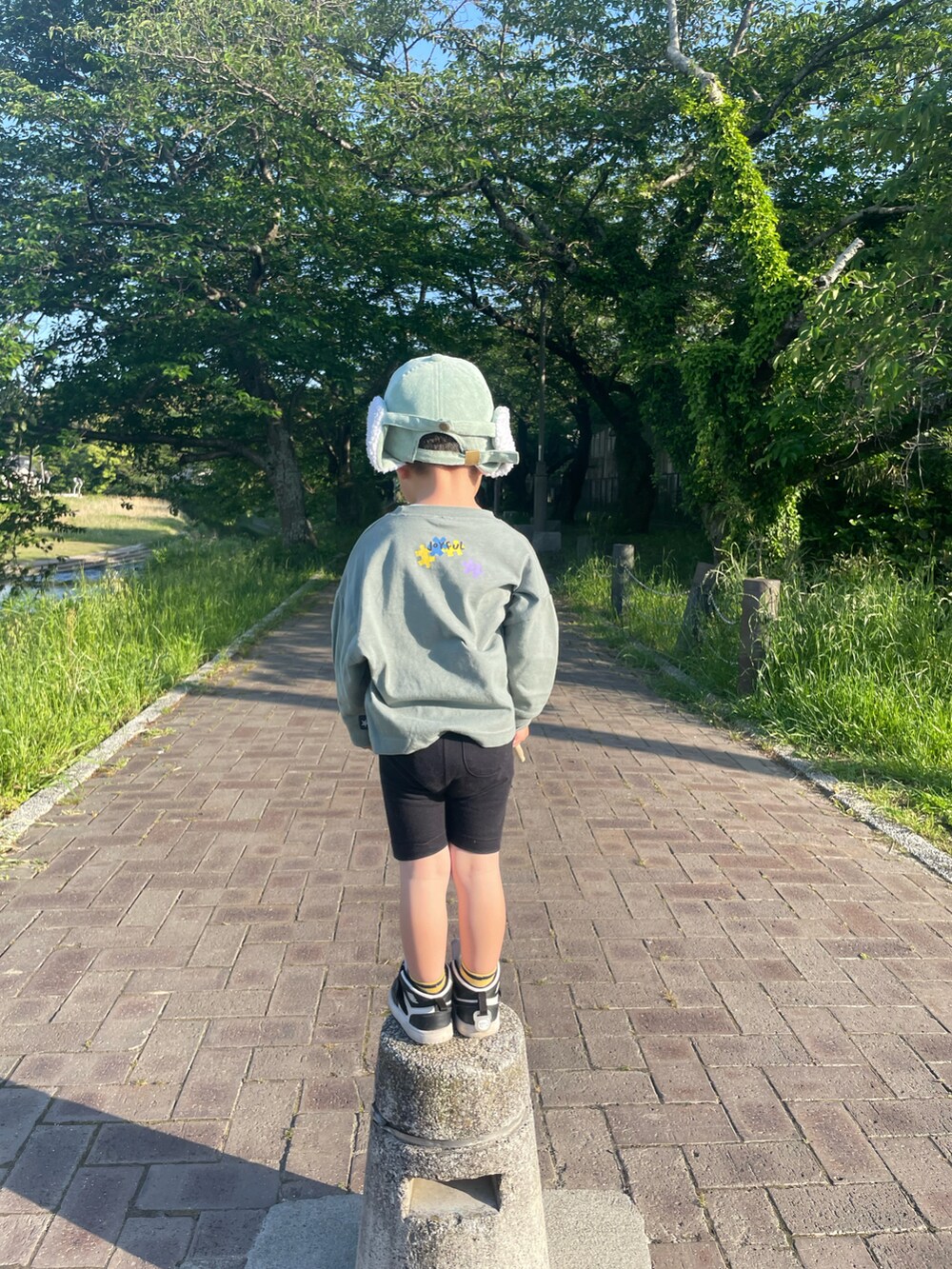 グリーン系のキャップを着用したキッズの夏コーディネートの2枚目の写真