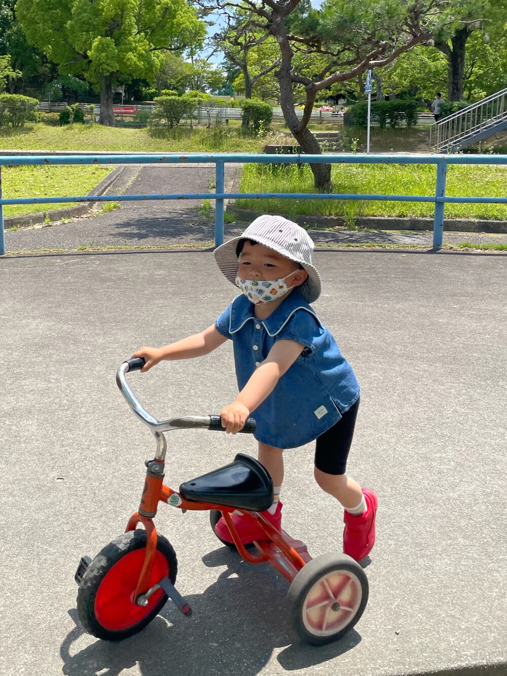 ブラック系のパンツ、レッド系のスニーカー、ホワイト系のハットを着用したキッズの夏コーディネートの2枚目の写真