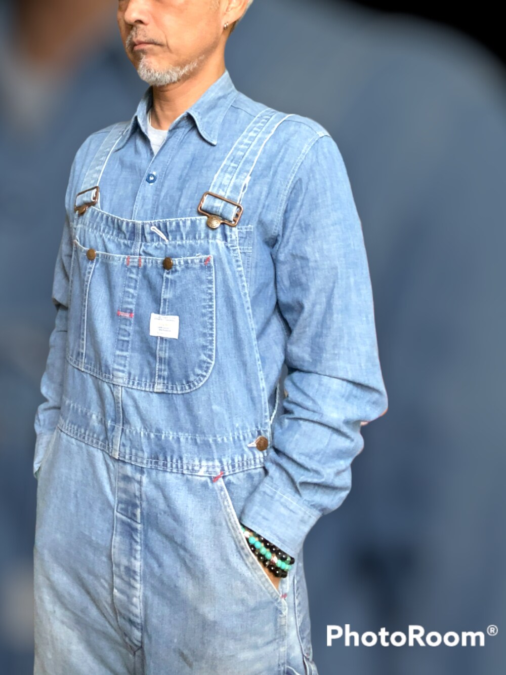 ブラック系のスニーカー、ブルー系のデニムパンツ、グリーン系のニット/セーターを着用したメンズの冬コーディネートの2枚目の写真