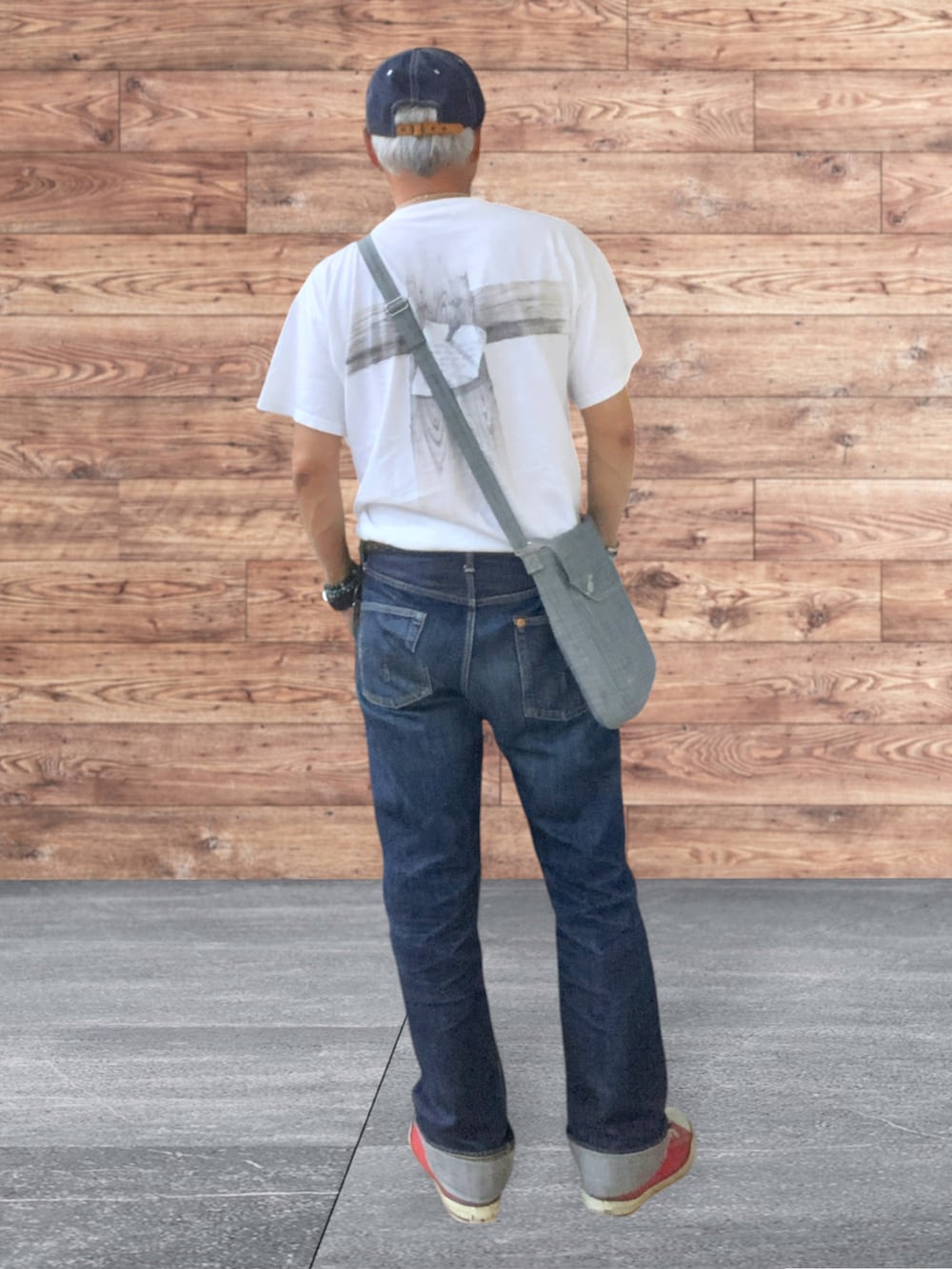 レッド系のスニーカー、ブルー系のデニムパンツ、ブルー系のキャップを着用したメンズの秋コーディネートの2枚目の写真
