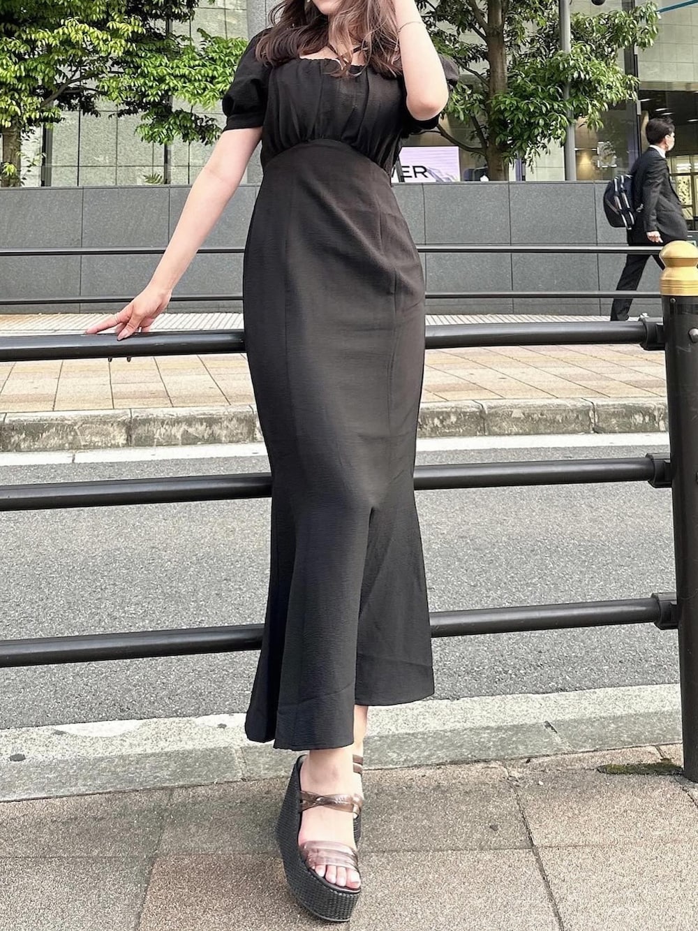 ブラック系のワンピース、ホワイト系のサンダル、ブラック系のキャスケットを着用したレディースの春コーディネートの2枚目の写真