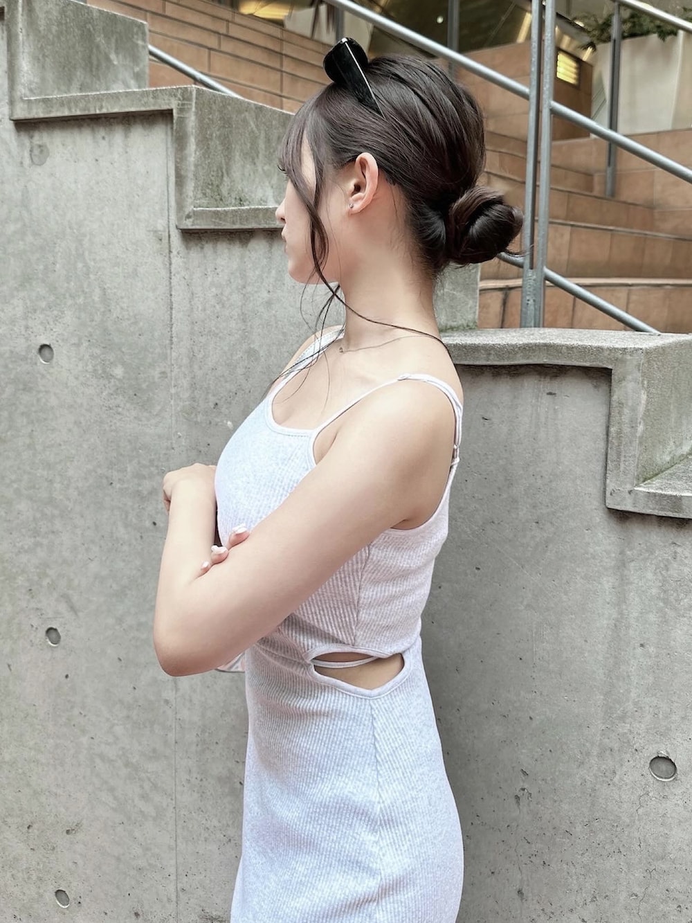 グレー系のワンピース、シルバー系のハンドバッグ、ブラック系のサンダルを着用したレディースの夏コーディネートの2枚目の写真