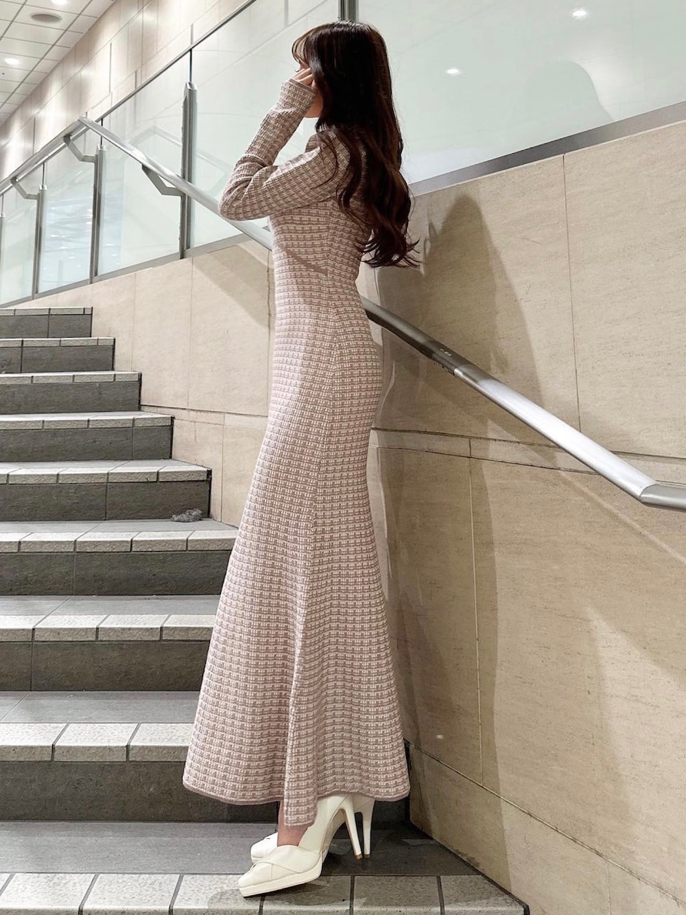 ピンク系のワンピース、ブラウン系のハンドバッグを着用したレディースの冬コーディネートの2枚目の写真