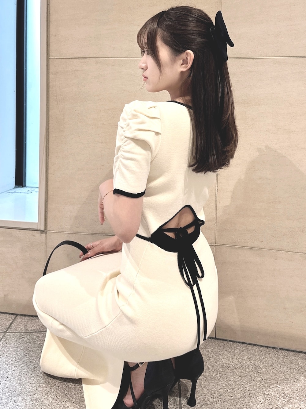 ホワイト系のワンピース、ホワイト系のパンプス、ブラック系のバレッタ/ヘアクリップを着用したレディースの春コーディネートの2枚目の写真