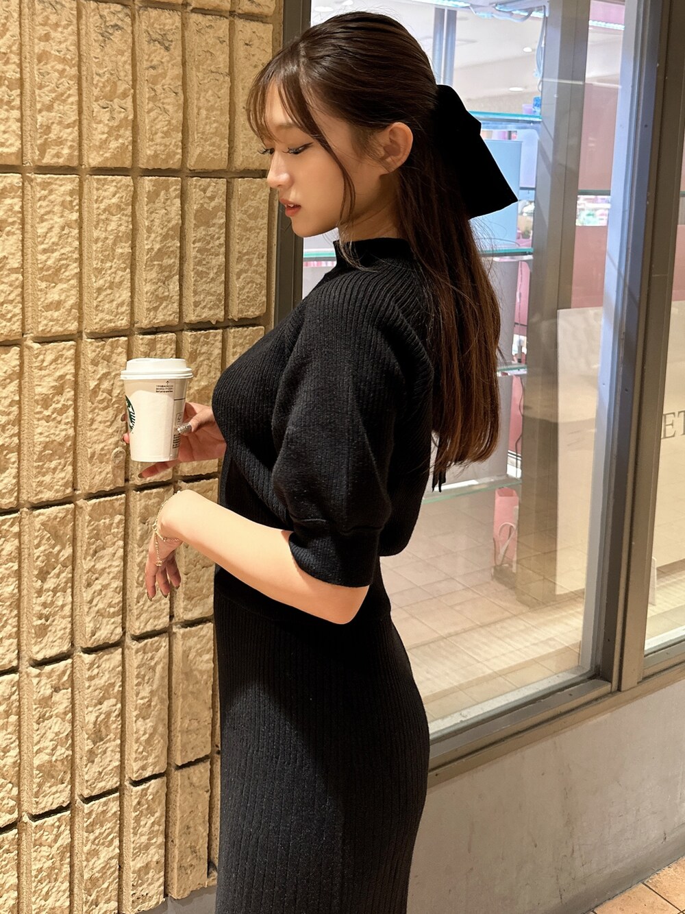 ブラック系のワンピース、ブラック系のサンダル、ブラック系のヘアゴムを着用したレディースの夏コーディネートの3枚目の写真