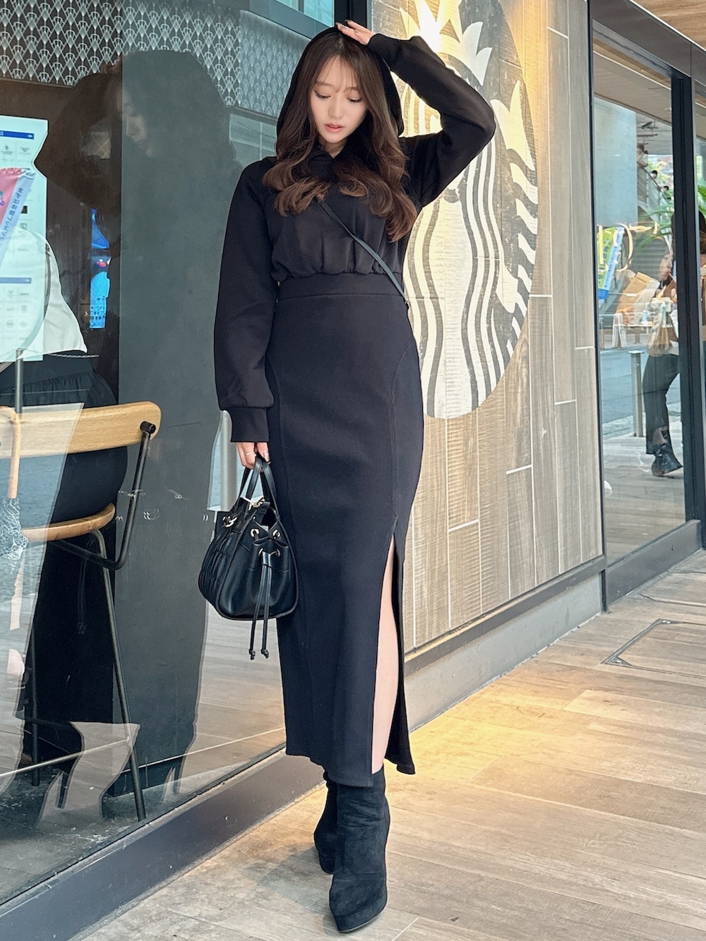 ブラック系のワンピース、ブラック系のブーツを着用したレディースの秋コーディネートの2枚目の写真