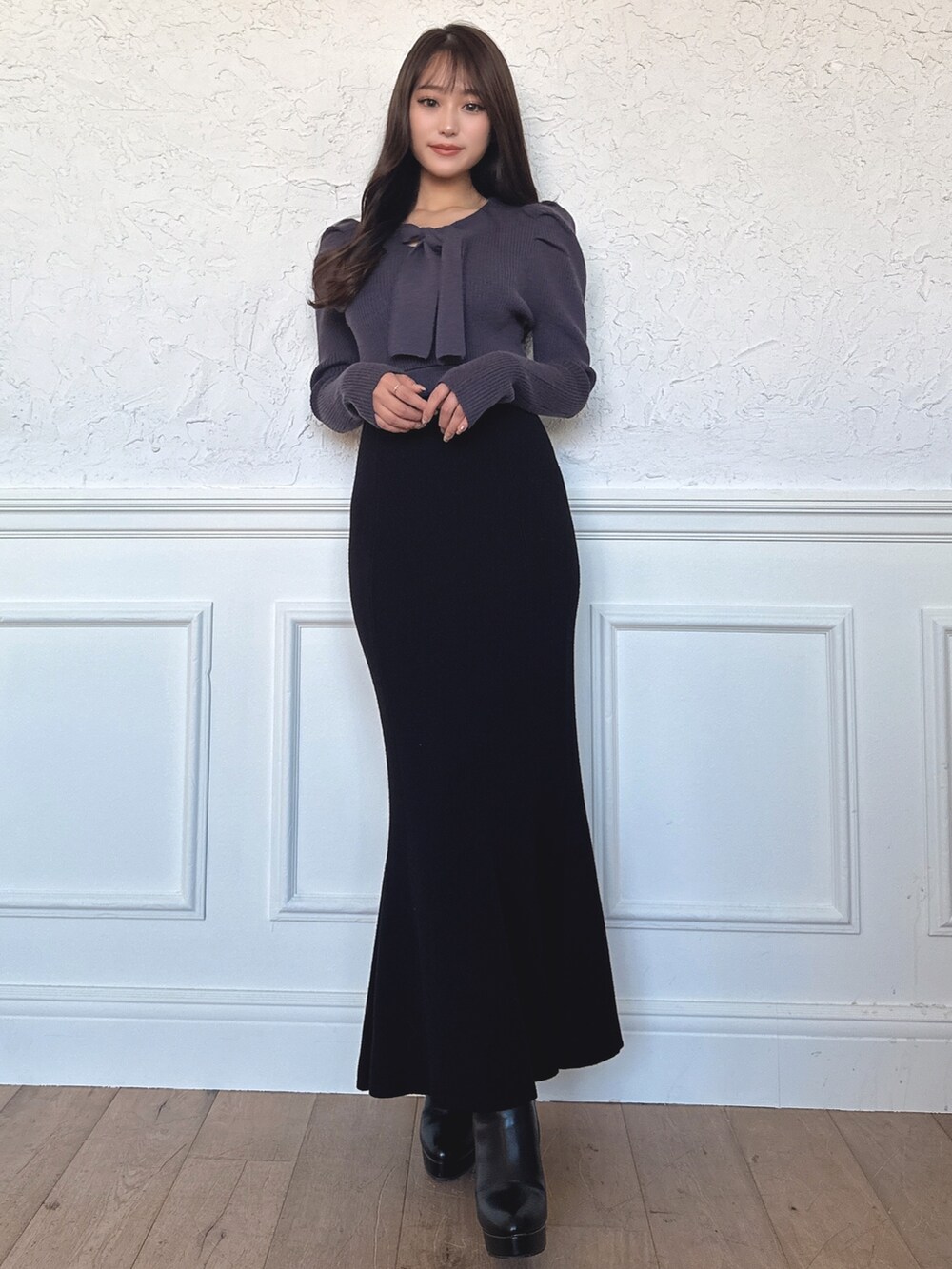 ブルー系のワンピース、ブラック系のブーツを着用したレディースの冬コーディネートの2枚目の写真