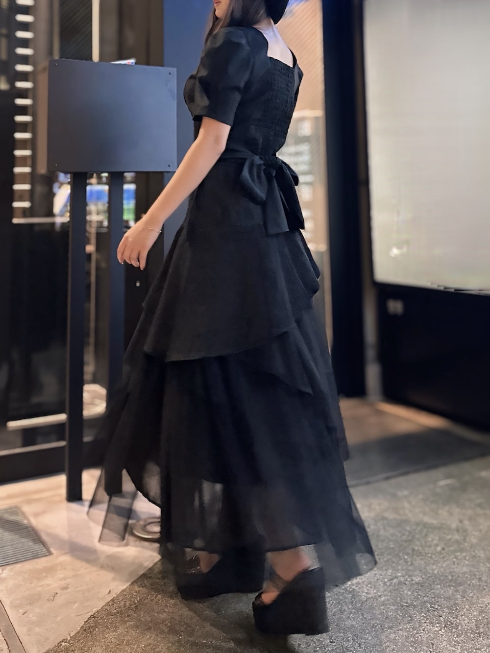 ブラック系のシャツ/ブラウス、ブラック系のデニムスカート、ブラック系のサンダルを着用したレディースの春コーディネートの2枚目の写真