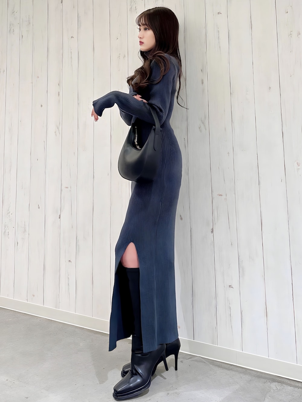 ホワイト系のワンピース、ブラック系のハンドバッグ、ブラック系のブーツを着用したレディースの冬コーディネートの2枚目の写真