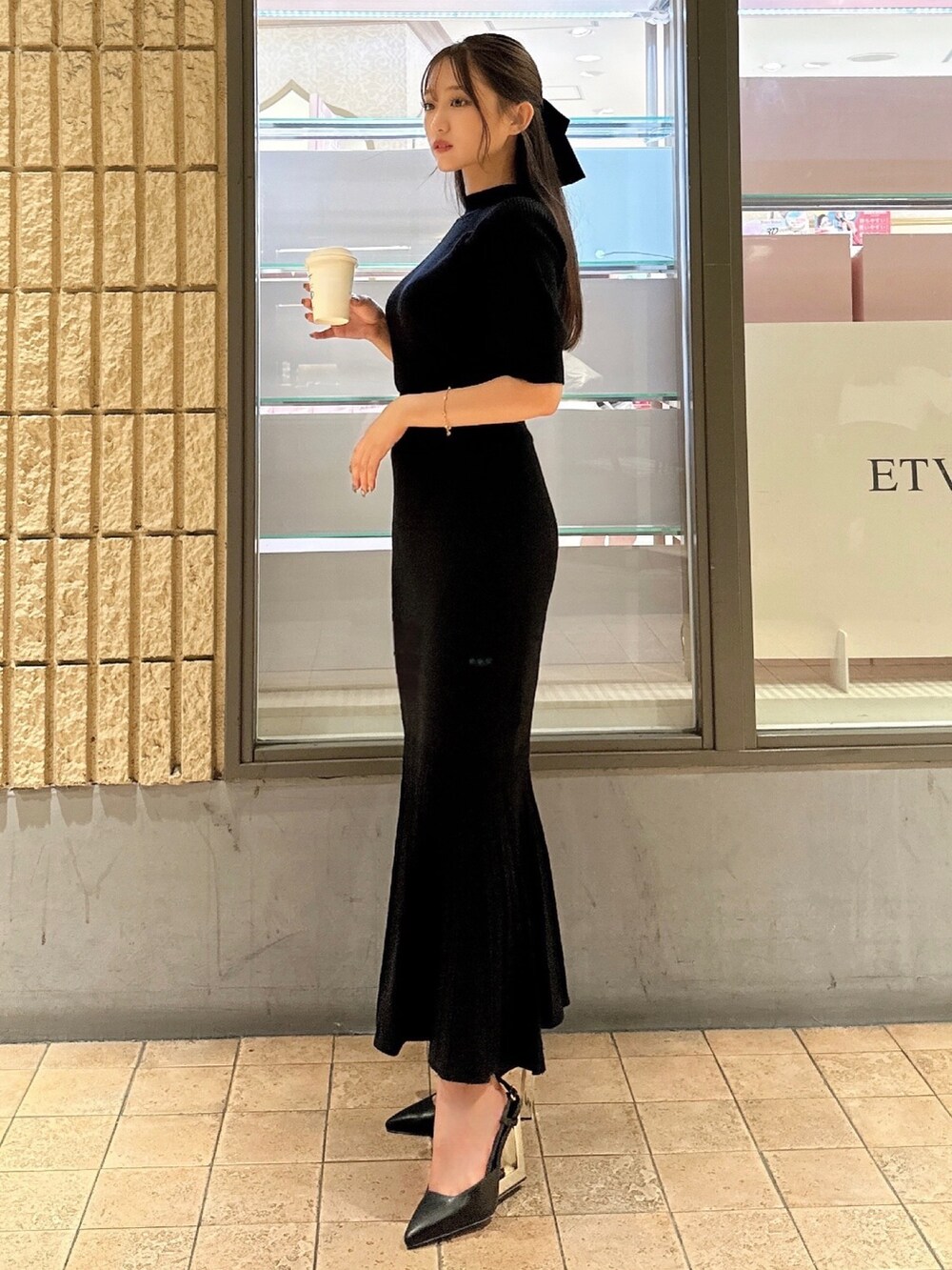 ブラック系のワンピース、ブラック系のサンダル、ブラック系のヘアゴムを着用したレディースの夏コーディネートの2枚目の写真