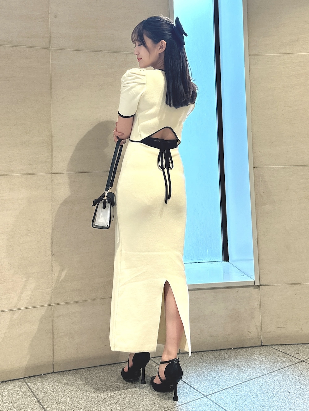 ホワイト系のワンピース、ホワイト系のパンプス、ブラック系のバレッタ/ヘアクリップを着用したレディースの春コーディネートの3枚目の写真
