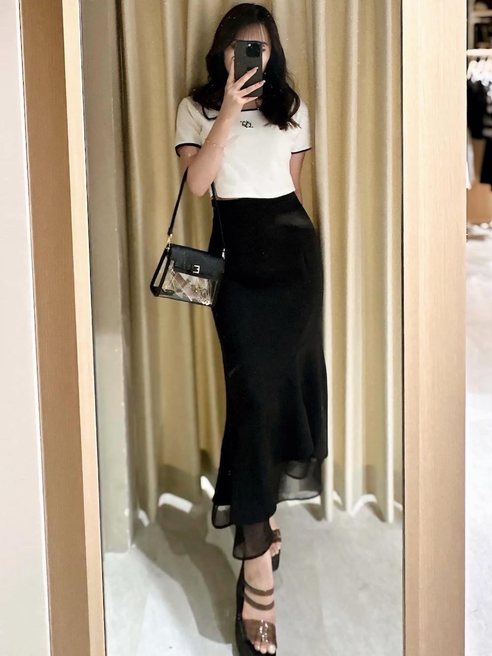 ホワイト系のTシャツ/カットソー、ブラック系のスカート、ブラック系のハンドバッグを着用したレディースの春コーディネートの2枚目の写真