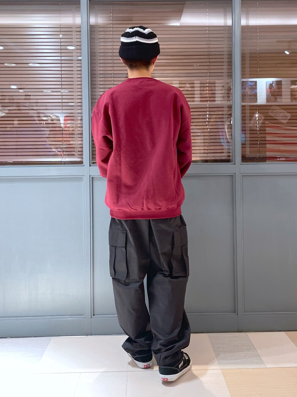 レッド系のスウェット、ブラック系のカーゴパンツ、ブラック系のニットキャップ/ビーニーを着用したメンズの冬コーディネートの2枚目の写真