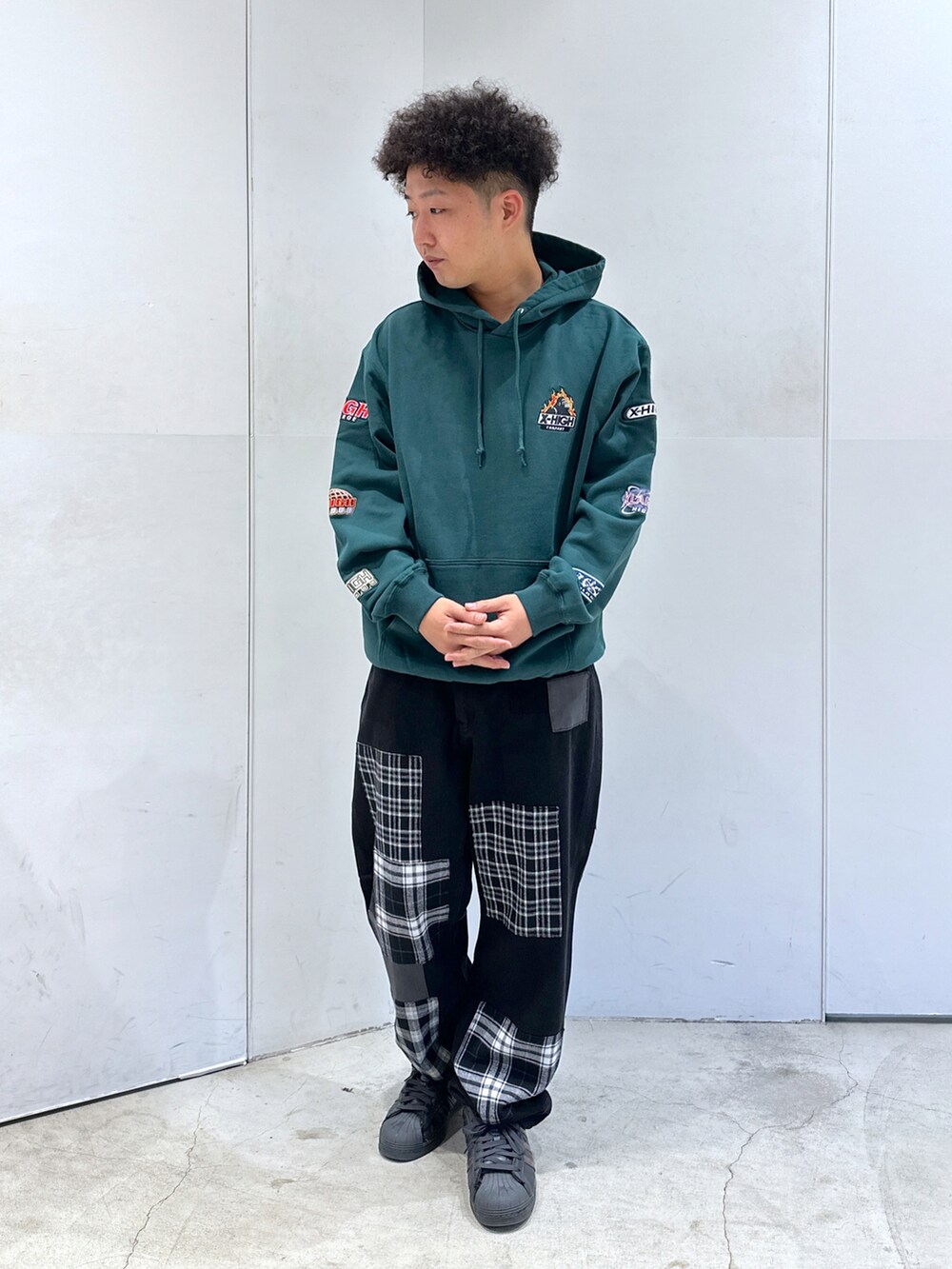 グリーン系のパーカー、ブラック系のデニムパンツを着用したメンズの秋コーディネートの2枚目の写真