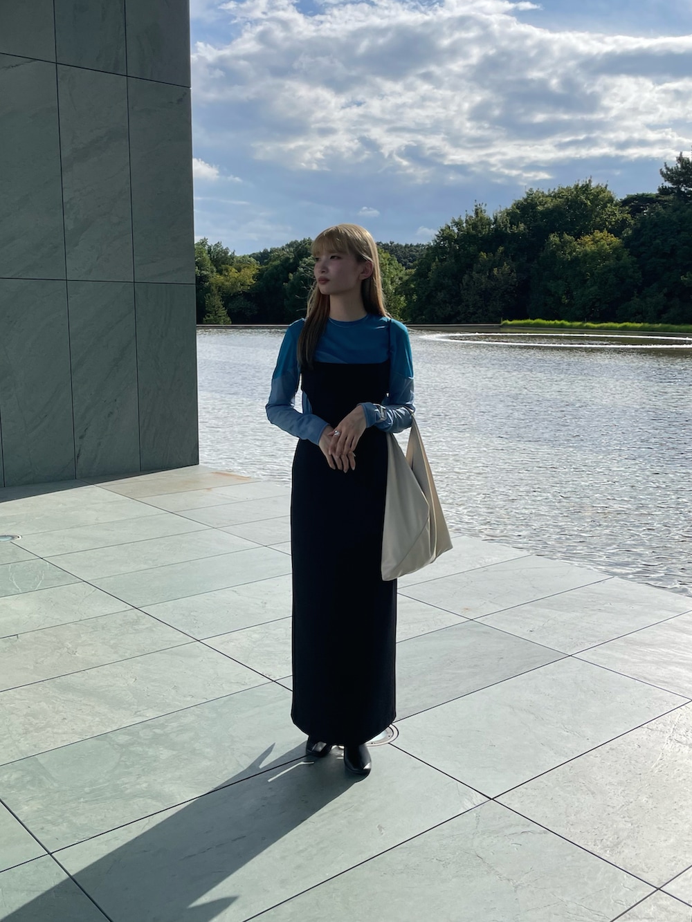 ホワイト系のトートバッグ、ブラック系のワンピース、ブルー系のTシャツ/カットソーを着用したレディースの冬コーディネートの3枚目の写真