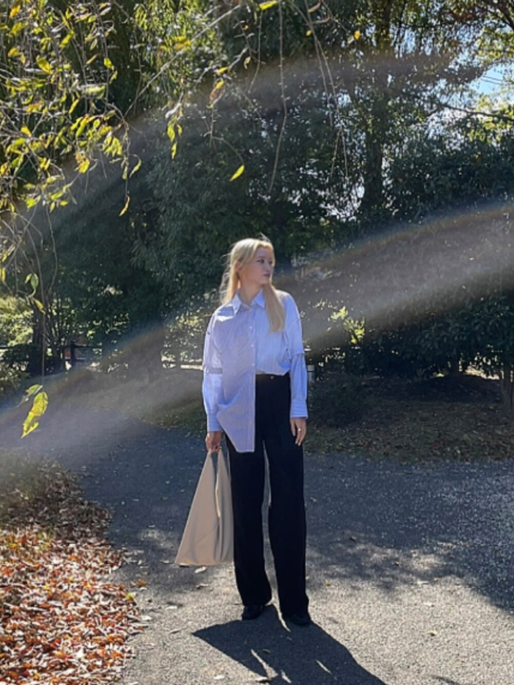 ブラック系のスラックス、ブルー系のシャツ/ブラウス、ホワイト系のバッグを着用したレディースの秋コーディネートの3枚目の写真