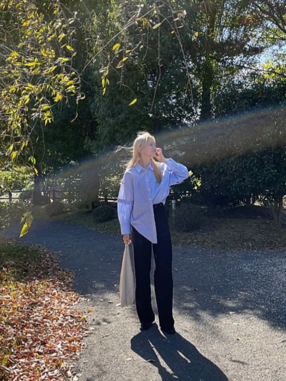 ブラック系のスラックス、ブルー系のシャツ/ブラウス、ホワイト系のバッグを着用したレディースの秋コーディネートの2枚目の写真