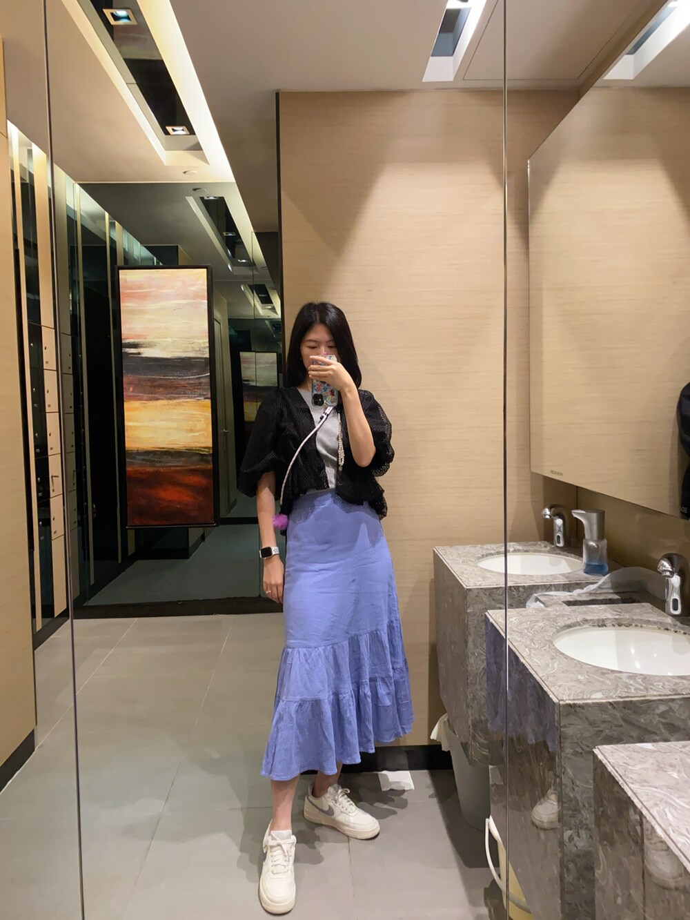 ブルー系のスカート、ブラック系のカーディガン/ボレロ、グレー系のニット/セーターを着用したレディースの秋コーディネートの2枚目の写真