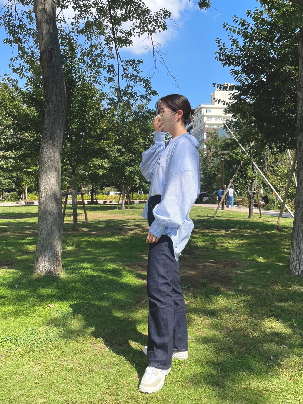 ブルー系のデニムパンツ、ホワイト系のTシャツ/カットソー、ブルー系のシャツ/ブラウスを着用したレディースの秋コーディネートの3枚目の写真