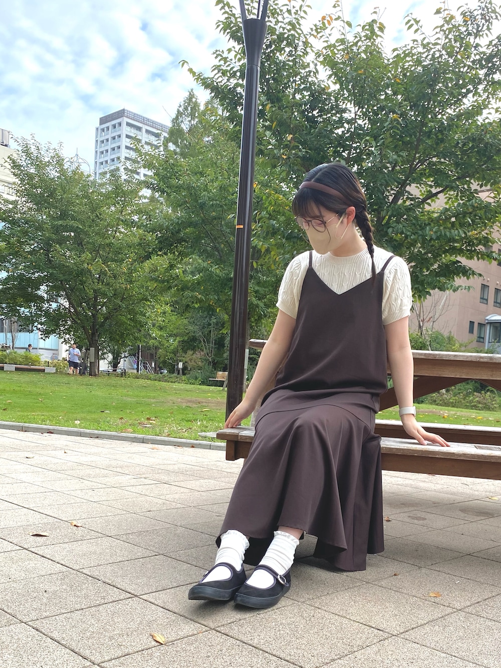 ブラウン系のワンピース、ブラック系のバレエシューズ、ホワイト系のニット/セーターを着用したレディースの秋コーディネートの3枚目の写真