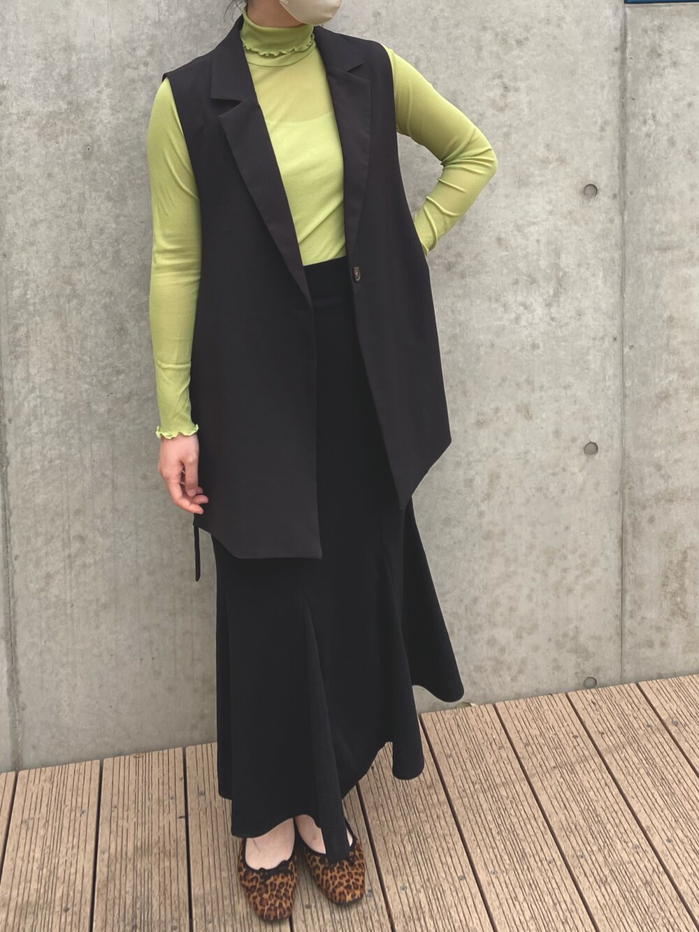 ブラウン系のバレエシューズ、ブラック系のスカート、グリーン系のその他トップスを着用したレディースの秋コーディネートの2枚目の写真