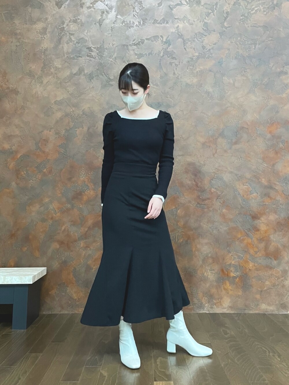 ホワイト系のブーツ、ブラック系のスカート、ブラック系のニット/セーターを着用したレディースの秋コーディネートの2枚目の写真