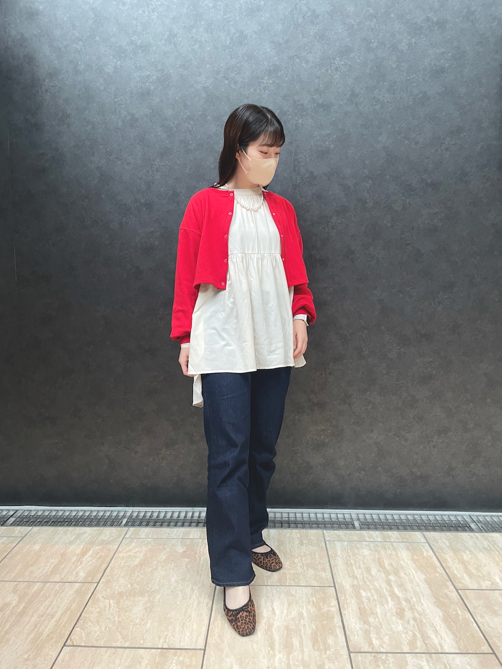 ブルー系のデニムパンツ、レッド系のカーディガン/ボレロ、ベージュ系のシャツ/ブラウスを着用したレディースの秋コーディネートの3枚目の写真