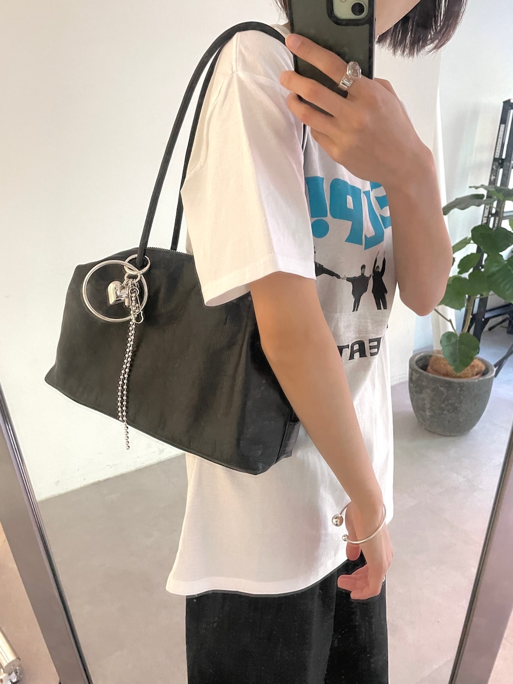 ブラック系のボストンバッグ、ブラック系のその他パンツ、ホワイト系のTシャツ/カットソーを着用したレディースの春コーディネートの3枚目の写真