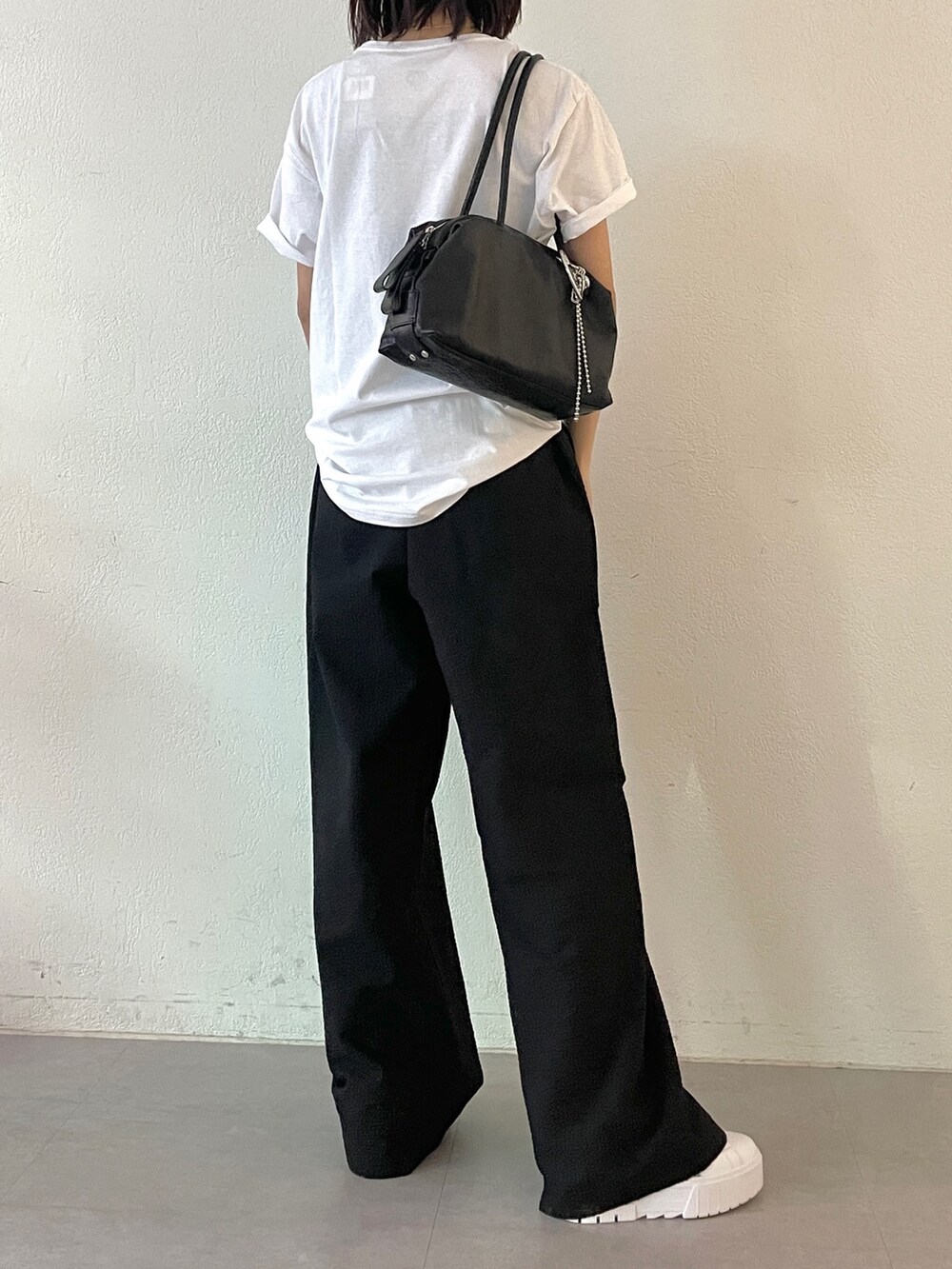ブラック系のボストンバッグ、ブラック系のその他パンツ、ホワイト系のTシャツ/カットソーを着用したレディースの春コーディネートの7枚目の写真