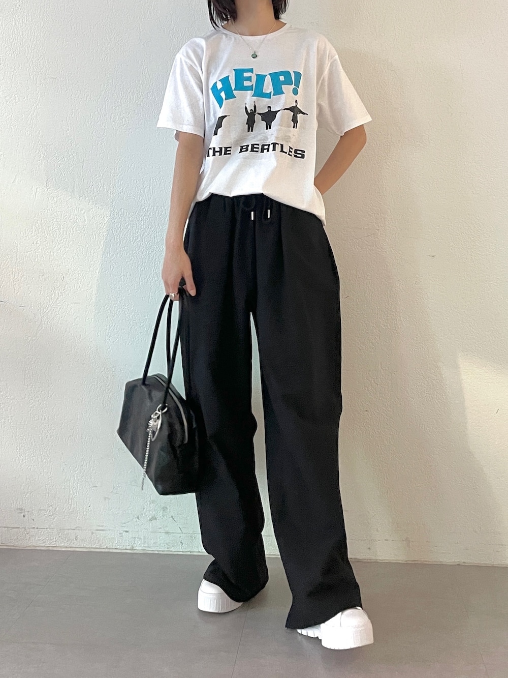ブラック系のボストンバッグ、ブラック系のその他パンツ、ホワイト系のTシャツ/カットソーを着用したレディースの春コーディネートの2枚目の写真