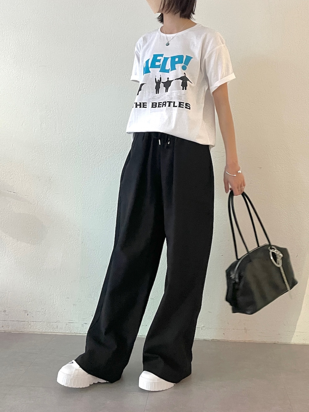 ブラック系のボストンバッグ、ブラック系のその他パンツ、ホワイト系のTシャツ/カットソーを着用したレディースの春コーディネートの5枚目の写真