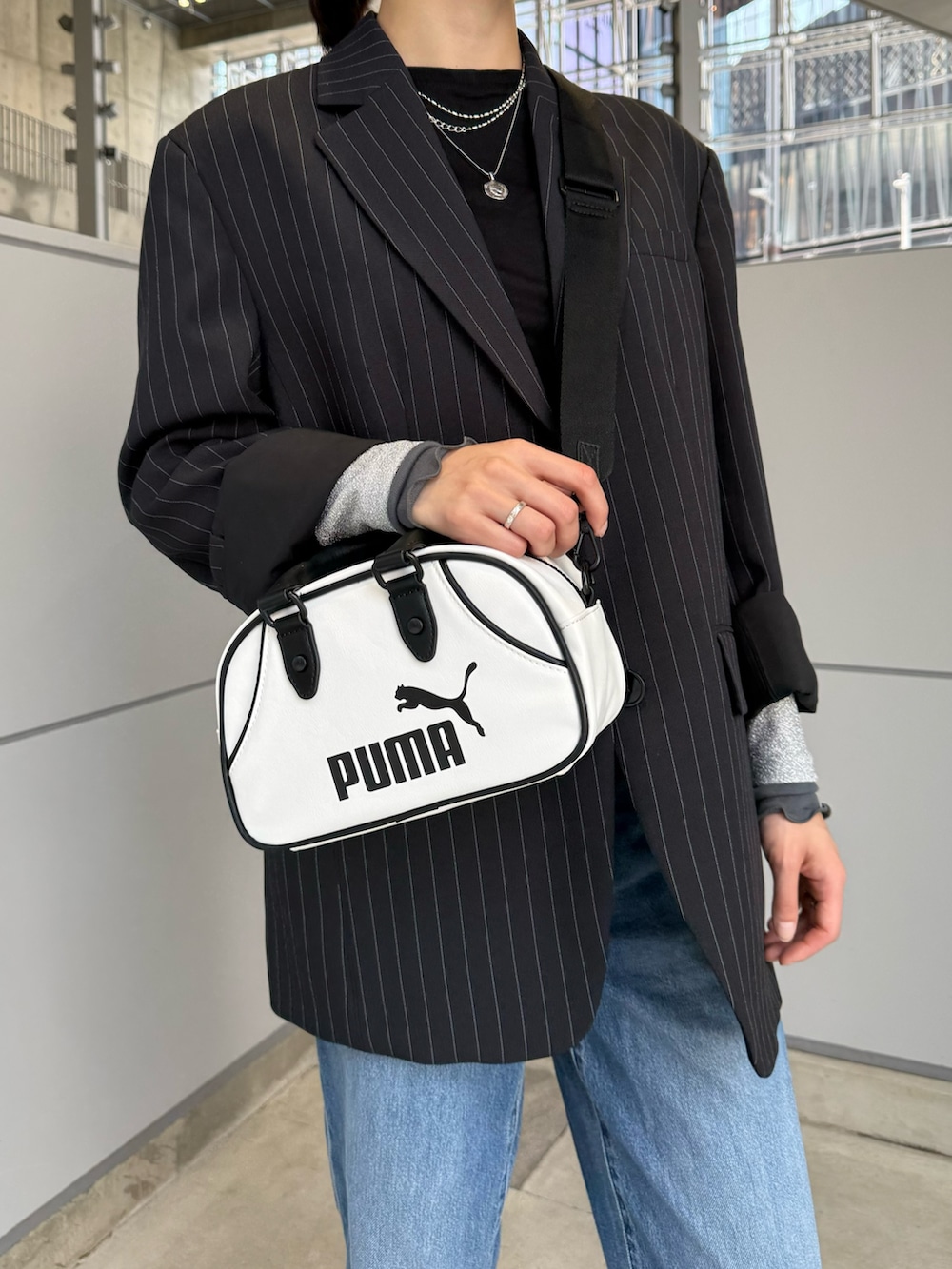 ホワイト系のボストンバッグ、ブラック系のTシャツ/カットソー、シルバー系のネックレスを着用したレディースの春コーディネートの2枚目の写真