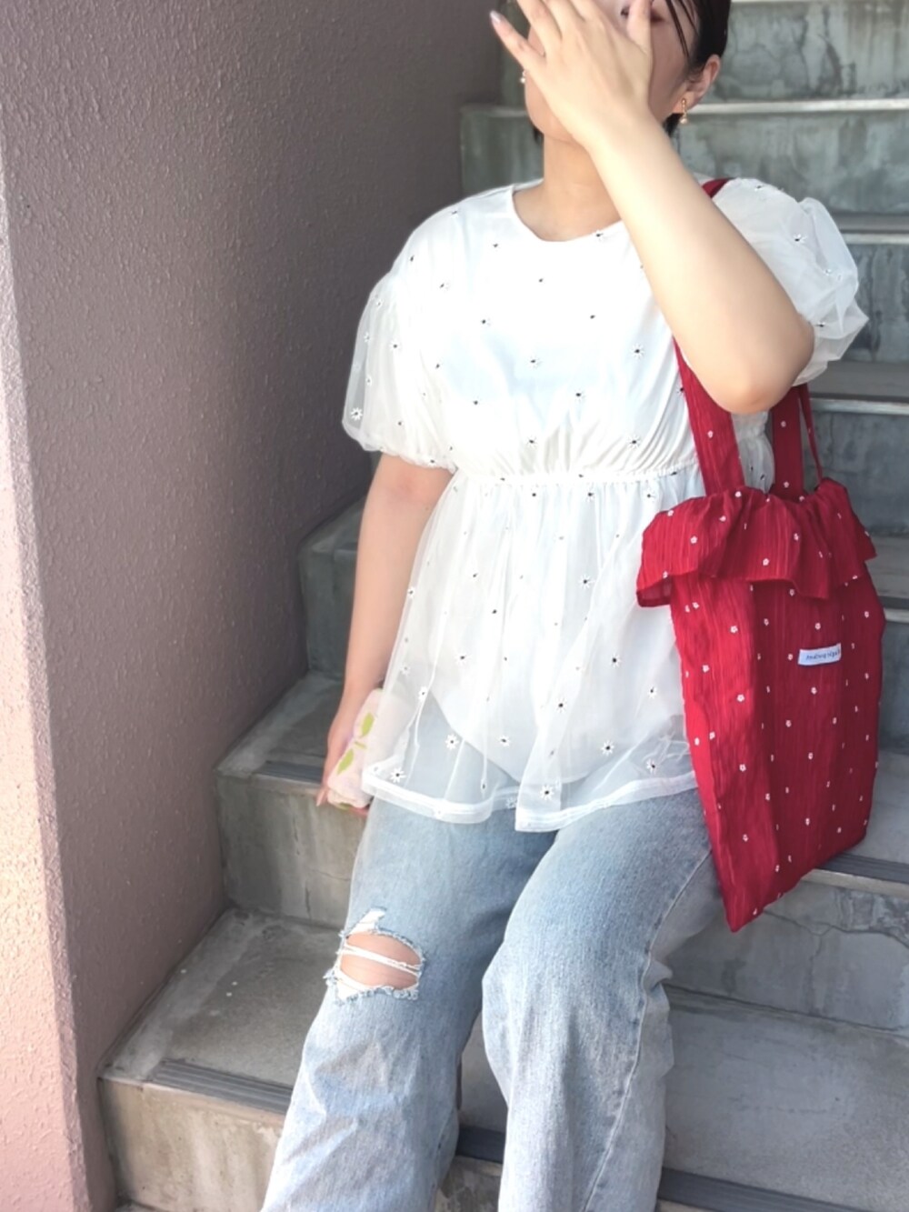 レッド系のトートバッグ、ホワイト系のTシャツ/カットソーを着用したレディースの夏コーディネートの2枚目の写真