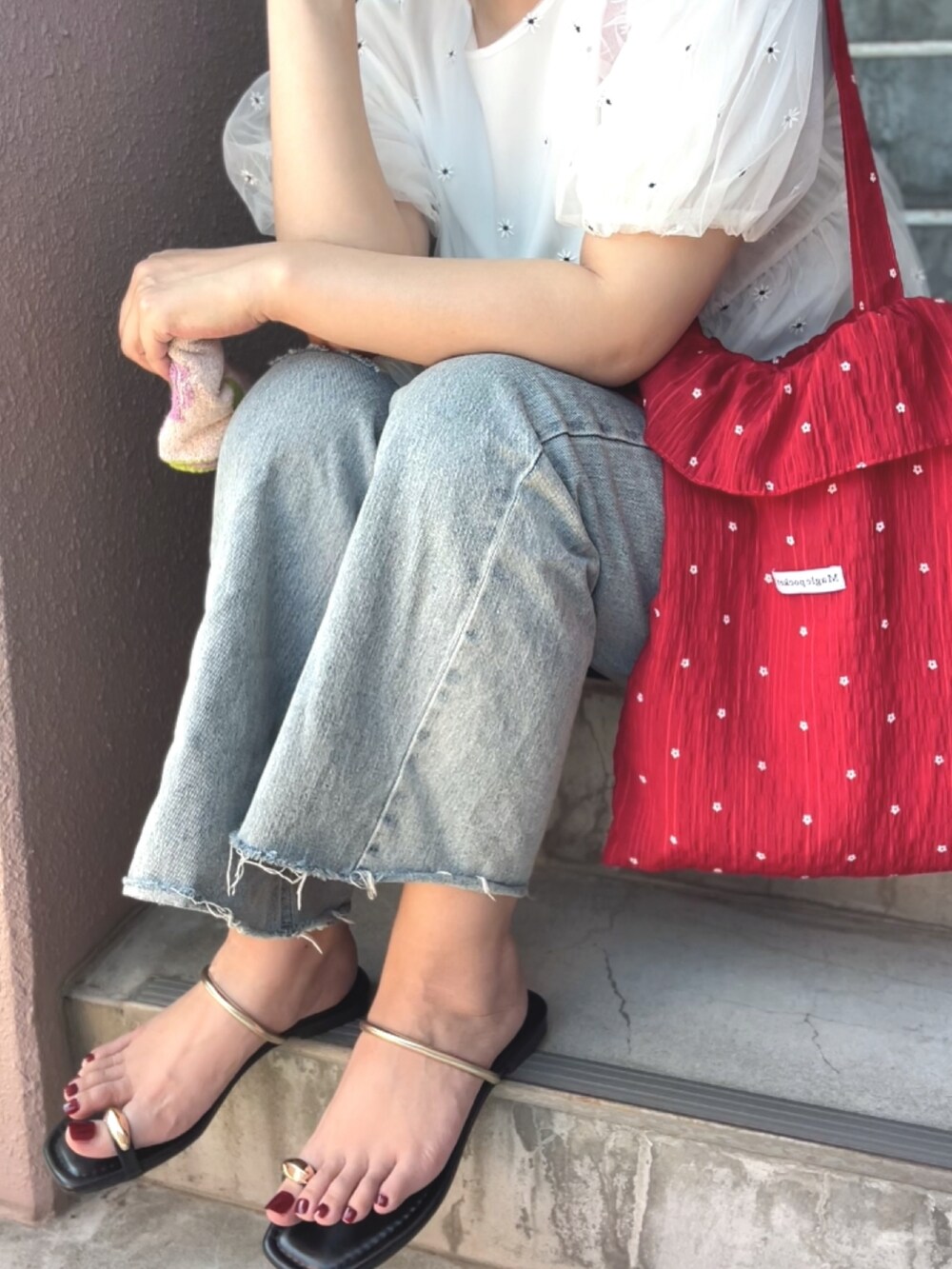 レッド系のトートバッグ、ホワイト系のTシャツ/カットソーを着用したレディースの夏コーディネートの3枚目の写真